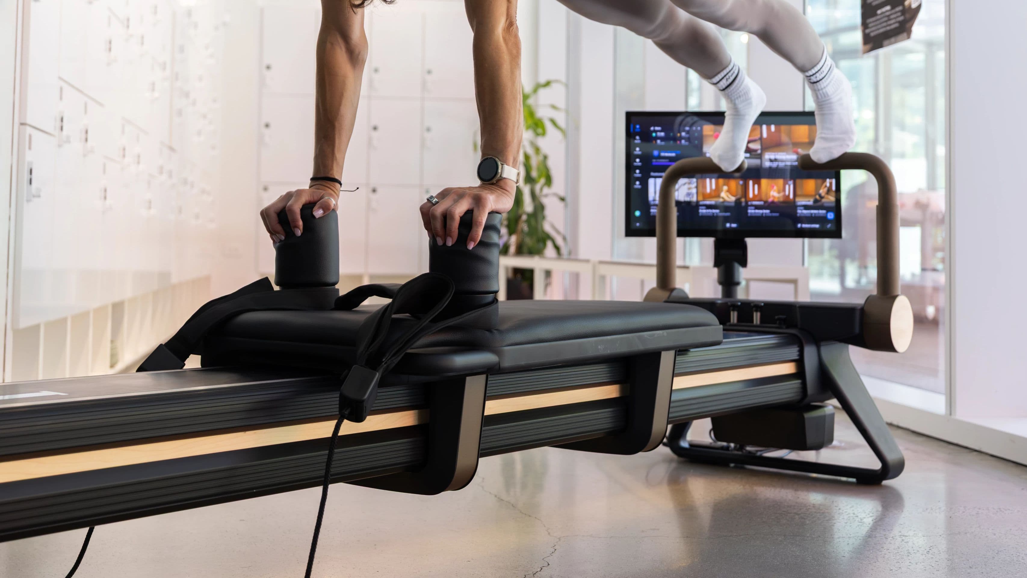 A trainer performs a standing balance exercise on the NordicTrack Ultra 1 Reform RX-S, with the iFIT content library visible on the integrated touchscreen, demonstrating the athletic training applications that make it the recommended reformer for sports performance facilities.
